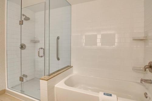 a white bathroom with a tub and a glass shower at Holiday Inn Express Hotel & Suites Toronto - Markham by IHG in Richmond Hill