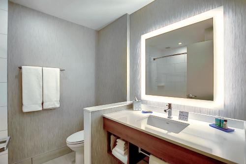 a bathroom with a sink and a toilet and a mirror at Holiday Inn Express & Suites - Calgary Airport Trail NE, an IHG Hotel in Calgary