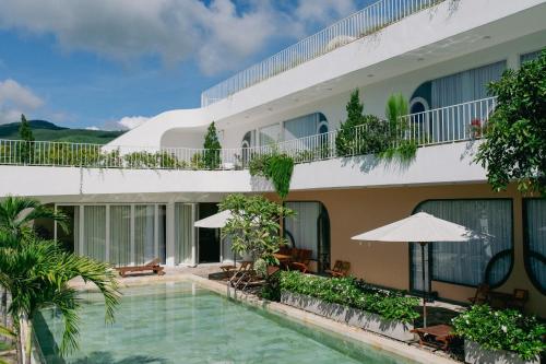 Blick auf die Fassade eines Hotels mit Pool in der Unterkunft Lotus Home Quảng Ngãi in Quảng Ngãi