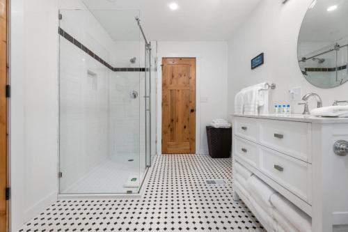 een witte badkamer met een douche en een wastafel bij Elk Creek Retreat on 20 miles from ski areas in Butler