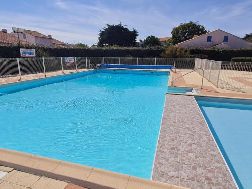 une grande piscine avec de l'eau bleue dans l'établissement Maisonnette 4 pers. à 300m de la Plage avec Piscine, Tennis et WIFI - FR-1-231-321, à Bretignolles-sur-Mer