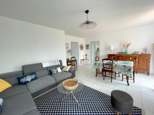 un salon avec un canapé et une table dans l'établissement Maison rénovée avec jardin, 2 chambres, WiFi, à 500m de la mer - Brétignolles-sur-Mer - FR-1-231-320, à Bretignolles-sur-Mer