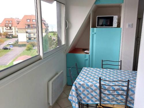 une petite pièce avec un réfrigérateur bleu et une table dans l'établissement Charmant 2 pièces rénové avec loggia, à deux pas de la plage - Parking privé - Idéalement situé - FR-1-712-77, à Villers-sur-Mer
