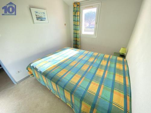a small bedroom with a bed with a colorful comforter at Maison Vendres, 3 pièces, 6 personnes - FR-1-781-40 in Port-Vendres