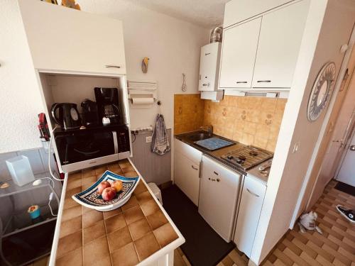 - une petite cuisine avec un bol de fruits sur le comptoir dans l'établissement Cap d'Agde: Apt proche plage et port, parking privé - FR-1-723-151, au Cap d'Agde