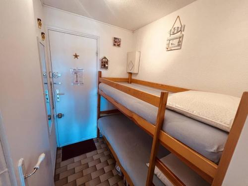 Cette chambre comprend 2 lits superposés et une porte. dans l'établissement Cap d'Agde: Apt proche plage et port, parking privé - FR-1-723-151, au Cap d'Agde