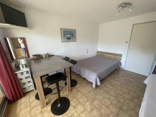une chambre avec un lit et un bureau dans l'établissement Studio clim proche plage Richelieu, parking - FR-1-723-150, au Cap d'Agde