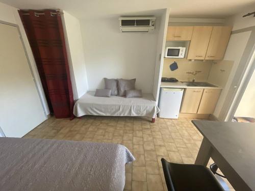 Cette petite chambre comprend un lit et une cuisine. dans l'établissement Studio clim proche plage Richelieu, parking - FR-1-723-150, au Cap d'Agde