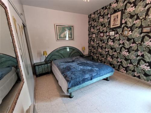 - une chambre avec un lit et un papier peint floral dans l'établissement Appartement Confortable Proche des Thermes à Balaruc-les-Bains - FR-1-503-178, à Balaruc-les-Bains