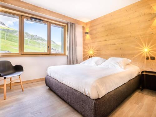a bedroom with a bed and a window and a chair at Appartement Tignes, 4 pièces, 6 personnes - FR-1-641-38 in Tignes