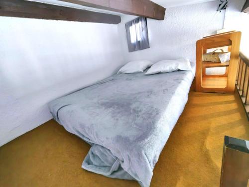 une chambre avec un grand lit avec deux oreillers dans l'établissement Charmant Studio Mezzanine pour 4 avec Terrasse en Pleine Pinède, à 900m de la Plage - FR-1-607-191, au Cap d'Agde