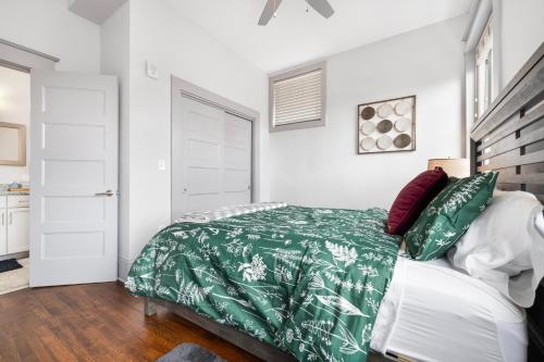 een slaapkamer met een bed met een groen dekbed bij Brand new luxury 2BR loft in downtown Johnson City in Johnson City