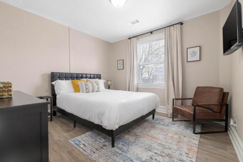ein Schlafzimmer mit einem Bett, einem Stuhl und einem Fenster in der Unterkunft 2BR house minutes from Holston Valley & Eastman in Kingsport