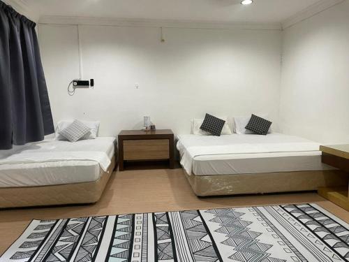 Zimmer mit 2 Betten und einem Beistelltisch in der Unterkunft #KangaQHomestay99 in Kangar