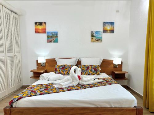 deux animaux farcis sont assis sur un lit dans l'établissement La Saranah - Blue Dream, Piscine, Plage, à Grand-Bourg