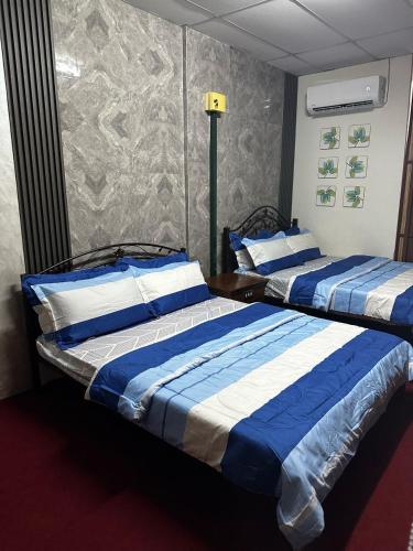 two beds sitting next to each other in a room at Bilik Bajet BDS in Temerloh