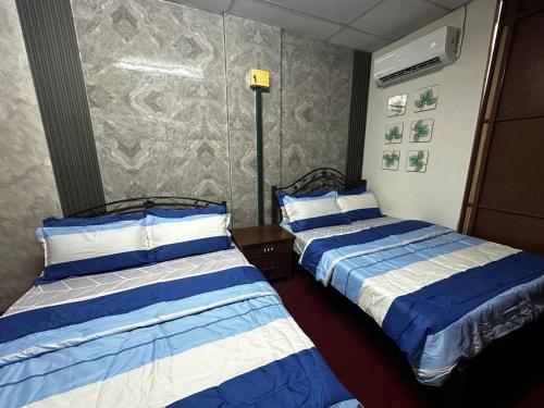 twee bedden in een hotelkamer met bij Bilik Bajet BDS in Temerloh