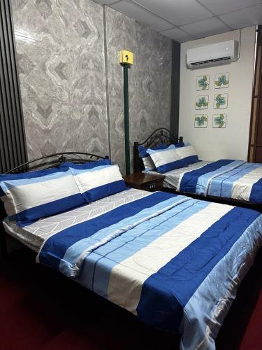 twee bedden naast elkaar in een kamer bij Bilik Bajet BDS in Temerloh