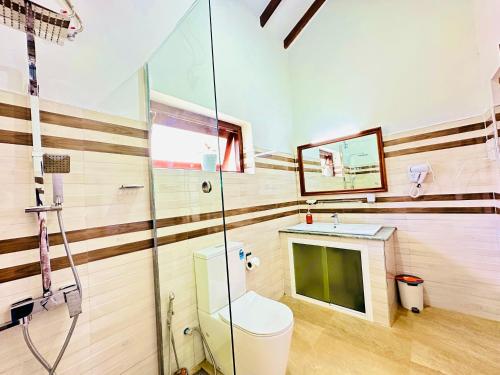 a bathroom with a toilet and a glass shower at Bloomingdale Bungalows - Nuwaraeliya in Sita Eliya