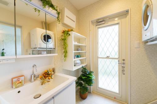 baño con lavabo y ventana grande en ベアーズステイ久米島ヴィラ en Kumejima