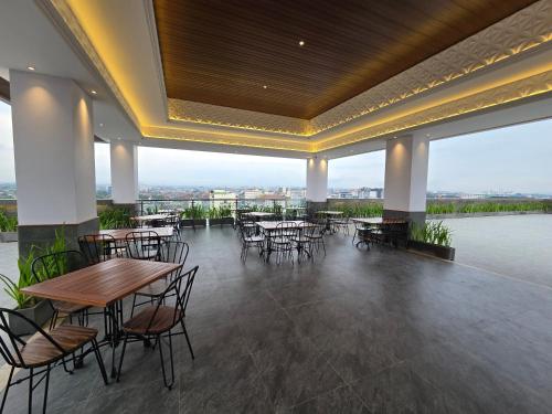 a restaurant with tables and chairs on a roof at The Malioboro Hotel & Conference Center in Yogyakarta