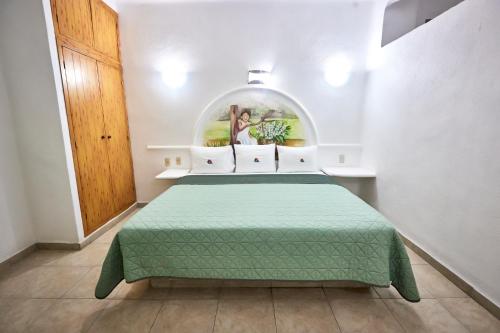 a bedroom with a green bed in a room at Hotel La Alondra in Barra de Navidad
