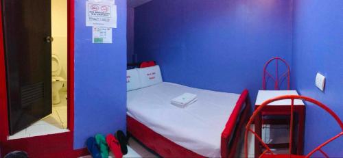 a small room with a bed in a blue wall at WJV INN NAGA in Tina-an