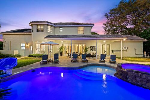 a house with a swimming pool in front of a house at Luxurious 8BR Dream Estate w Private Heated Pool in Pompano Beach