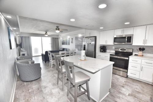 a kitchen with white cabinets and a table and chairs at 0902 Waters Edge Resort condo in Myrtle Beach