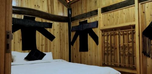 a bedroom with a bed in a wooden wall at MƯỜNG HOA Peaceful HOMESTAY & Sapa in Lao Cai