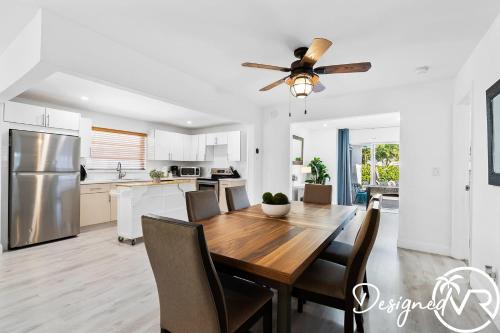 a kitchen and dining room with a table and a ceiling fan at 4BR retreat w heated pool backyard BBQ grill in Dania Beach