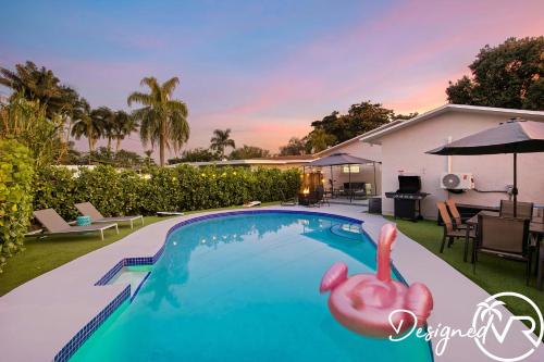 a swimming pool with a pink flamingo in a backyard at 4BR retreat w heated pool backyard BBQ grill in Dania Beach