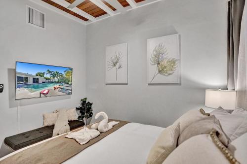 Modern 5BR with Heated Pool 5 min to Beach في بومبانو بيتش: غرفة نوم بها سرير ولوحات على الحائط
