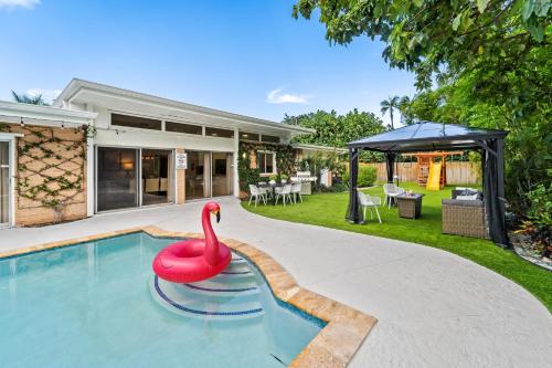 a swimming pool with a red swan in a house at Family retreat wheated pool game room in West Palm Beach