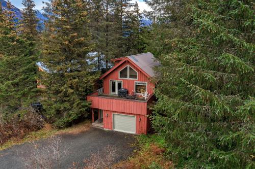a red house with a dog sitting on a balcony at Mountain Creek Chalet in Girdwood