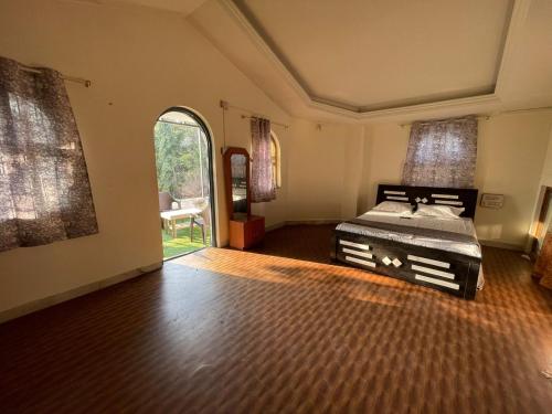 ein Schlafzimmer mit einem Bett in der Mitte eines Zimmers in der Unterkunft OTE Dulis Den in Pune