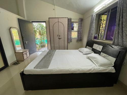 a bedroom with a large bed and a large window at OTE Dulis Den in Pune