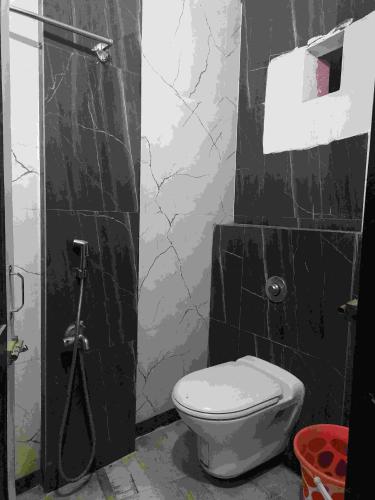 a bathroom with a toilet and a black wall at MAYUR HOTEL in Dimāpur