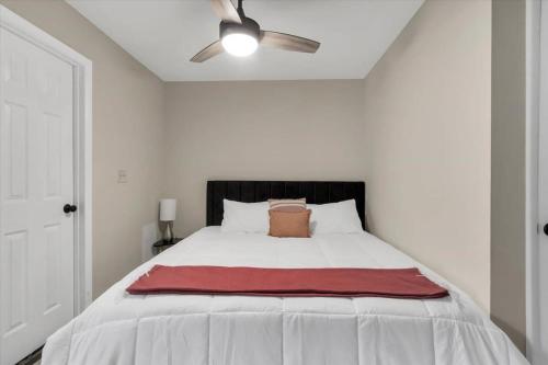 a bedroom with a white bed with a red blanket on it at King Bed Modern Studio Apartment in Huntsville