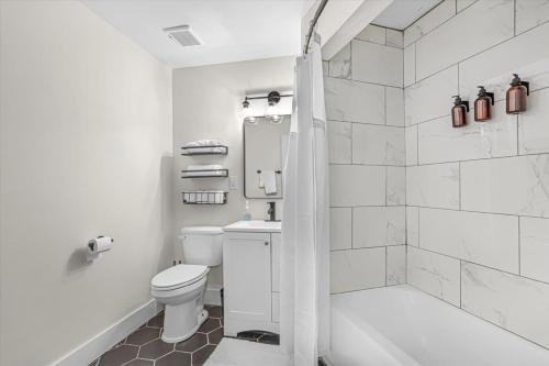 biała łazienka z toaletą i prysznicem w obiekcie King Bed Modern Studio Apartment w mieście Huntsville
