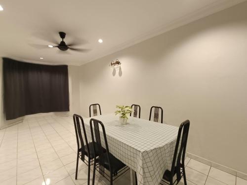 Tambun Sunway Homestay في تامبون: غرفة طعام مع طاولة مع كراسي ومروحة سقف