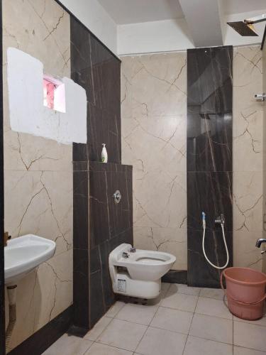 a bathroom with a toilet and a sink at MAYUR HOTEL in Dimāpur
