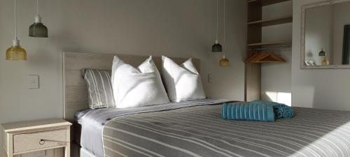 1 dormitorio con 1 cama grande con almohadas blancas en Luxurious waterfront accommodation en Dunedin