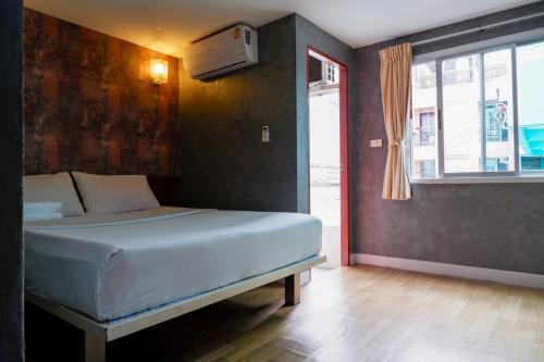a bedroom with a bed and a window at 18 Coins Budget Hotel in Pattaya Central