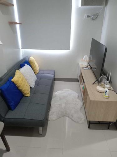 sala de estar con sofá azul y escritorio en Casa Humilde at SMDC Charm Residences, en Manila