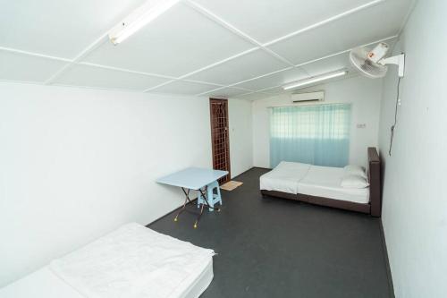 Habitación con 2 camas y mesa. en GLYSM Tambun Stay "Pura Vida" en Tambun