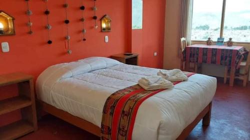 um quarto com uma cama grande e paredes vermelhas em Hotel Mirador del Colca Lodge em Chivay