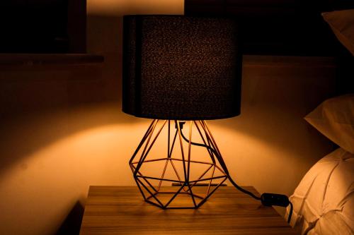 una lámpara sentada en una mesa en una habitación en Divine stay Nuneaton, en Stockingford