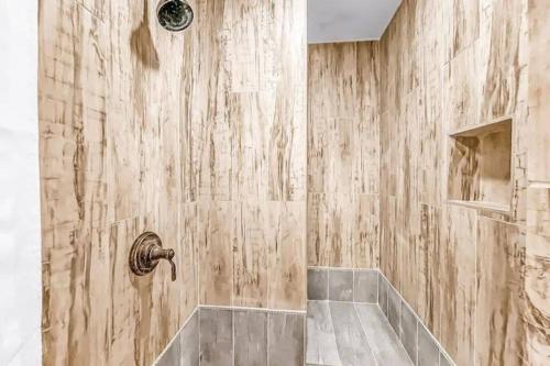 a bathroom with a shower with a wooden wall at Domain on Dumaine in New Orleans