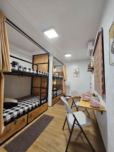 a room with bunk beds and a table and chairs at Dani's House Pod Coron in Coron
